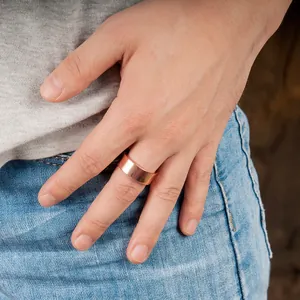 Minimalist 8mm polished red copper magnetic ring shown on hand with denim jeans