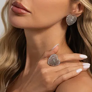 Detail shot of silver mesh heart ring and earrings on a model, elegant jewelry set.