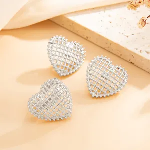 Close-up detail of elegant silver heart-shaped hollow mesh stud earrings for women