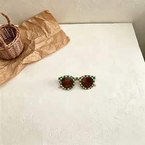 Retro round kids sunglasses with green and cream checkerboard frames and UV protection lenses