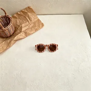 Detailed view of retro kids sunglasses with stylish striped pattern on white texture