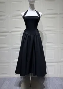 Full-length view of an elegant black halter neck evening dress with a pleated puffy skirt.