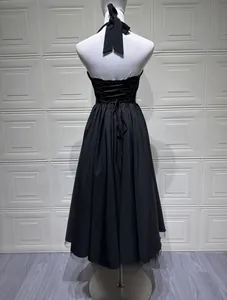 Close-up detail of black halter evening dress featuring a corset-style lace-up back design.