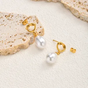 Detailed close-up of 18K gold plated knotted earrings with white drop pearls
