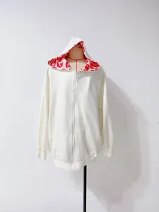 Sweat à capuche zippé oversize blanc avec doublure motif lèvres rouges à l'intérieur.