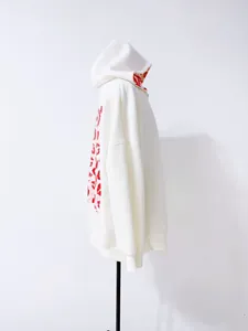 Vue latérale détaillée d'un sweat à capuche blanc oversize avec motifs lèvres rouges