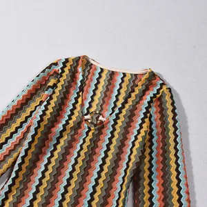 Detailed view of the V-neckline on a colorful zigzag pattern dress featuring a gold ring