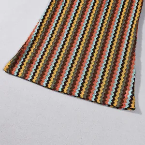 Close-up view of the colorful zigzag pattern and textured hem on a knitted midi dress