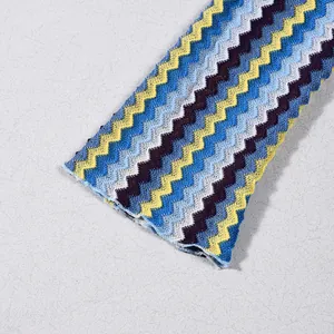 Close-up detail of colorful yarn-dyed zigzag knit pattern on a V-neck long-sleeved dress.