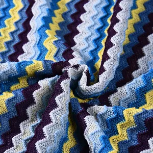 Detailed macro view of colorful zigzag knit pattern on autumn long sleeve dress fabric.