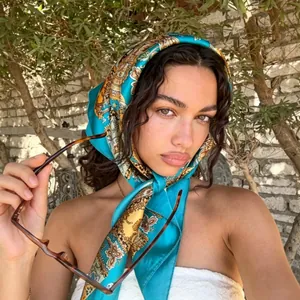 Elegant floral printed silk satin square scarf worn by a model in outdoor lighting