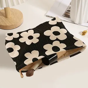 Large floral print corduroy cosmetic bag with secure gold zipper closure for travel.