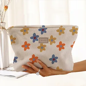 Close-up of hand-painted floral corduroy makeup bag with zipper closure and patterns