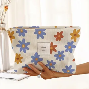 Macro view of a floral corduroy makeup bag with hand-drawn pattern and zipper closure