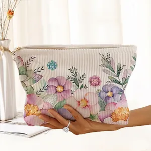 Macro view of hand-painted floral pattern detail on cream corduroy cosmetic pouch