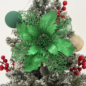 Close-up detail of a vibrant green glittery poinsettia flower on a snowy Christmas tree