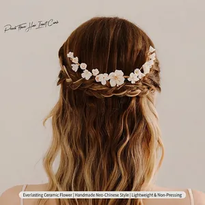 Detail view showing a handmade white ceramic flower hair comb styled in a bridal braid