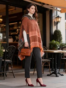 Full-length lifestyle shot of women's hooded poncho with classic orange herringbone pattern