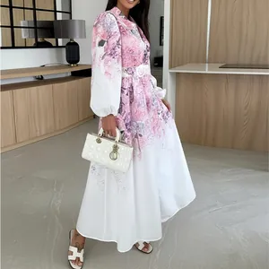 Detail of elegant floral high-waist shirt dress with long sleeves in white and pink