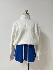 Detailed view of white half-zip sweatshirt and blue athletic shorts set on a mannequin