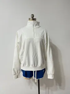Detailed view of white half-zip sweatshirt and blue sports shorts set on mannequin