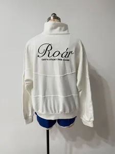Detailed back view of white half-zip sweatshirt with Roar print and blue sports shorts