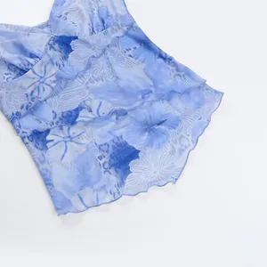 Close-up view of blue floral print mesh camisole with delicate ruffle hem detailing