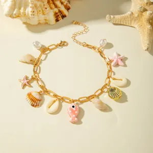 Macro detail of Bohemian gold anklet featuring shell, starfish, and pink ceramic fish charms