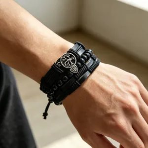Detail view of a men's vintage multi-layer black leather bracelet with tree of life charm