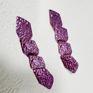 Vue détaillée de boucles d'oreilles pendantes géométriques violettes texturées style rétro