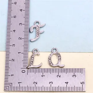 Detail view of rhinestone-encrusted alphabet charms with measuring ruler for size