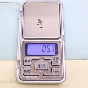 Detail view of silver alloy letter pendant on a digital scale showing 0.57g weight