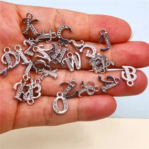 Detailed view of silver alloy alphabet charms with sparkling CZ stones for DIY jewelry