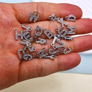 Macro view of 26 silver alloy alphabet charms with sparkling rhinestone inlays