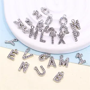 Detailed macro view of sparkling silver rhinestone alphabet charms for DIY jewelry.