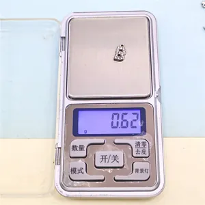 Macro view of DIY silver alloy 'B' letter charm weighing 0.62g on a mini digital scale