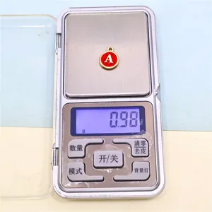 Macro view showing the 0.98g precise weight of a red enamel letter A alloy charm
