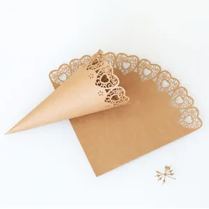 Detailed macro view showing the laser cut heart pattern on brown kraft wedding confetti cones