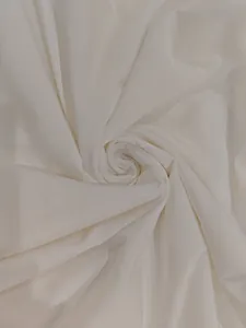 Close-up of soft white fabric texture showing delicate spiral folds for a summer dress.