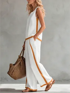 Detail view showing side orange stripes on white sleeveless top and wide-leg trousers