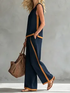 Profile view of stylish navy sleeveless top and wide-leg pants set with tan side stripes