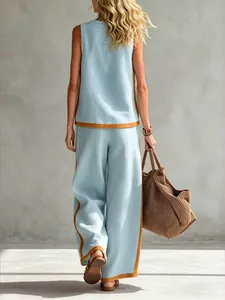 Back view of a casual light blue two-piece set with orange contrast trim and a large bag