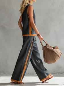 Side view of woman wearing grey sleeveless set with orange contrast trim and wide pants