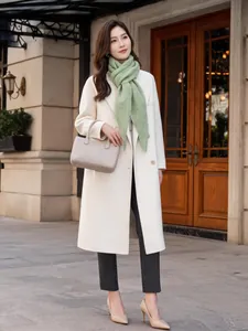Elegant model wearing a green knitted triangular wool shawl scarf in urban setting