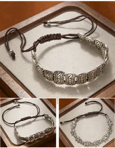 Detailed view of vintage Tibetan silver elephant and floral woven adjustable bracelets