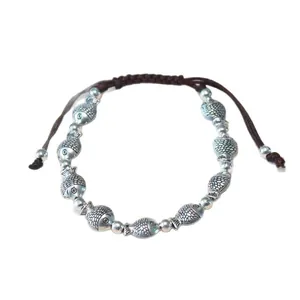 Ethnic handmade woven rope bracelet with silver-colored fish beads and adjustable closure