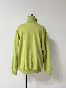 Vista posterior detallada de una sudadera verde lima para mujer con media cremallera y ajuste relajado