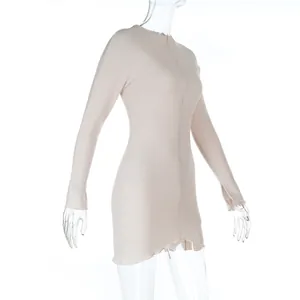 Dettaglio di un mini abito aderente in maglia a costine beige con maniche lunghe e bordi.