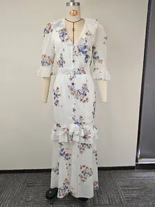 Détail d'une robe longue blanche à fleurs avec col et ourlet à volants