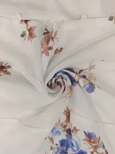 Vue détaillée d'un tissu en mousseline blanche légère avec imprimé fleuri bleu